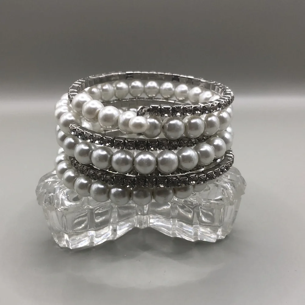 Faux pearls and rhinestones coil statement bracelet wide.